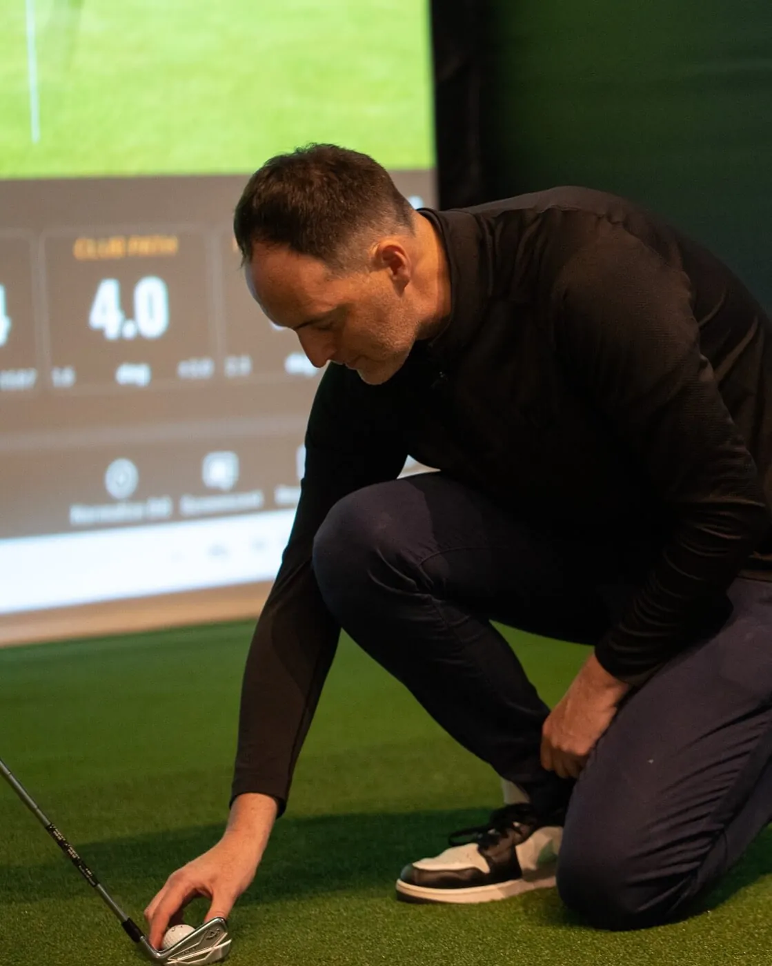 professional coach Mark Curtis coaching in a Trackman bay at Grip Golf