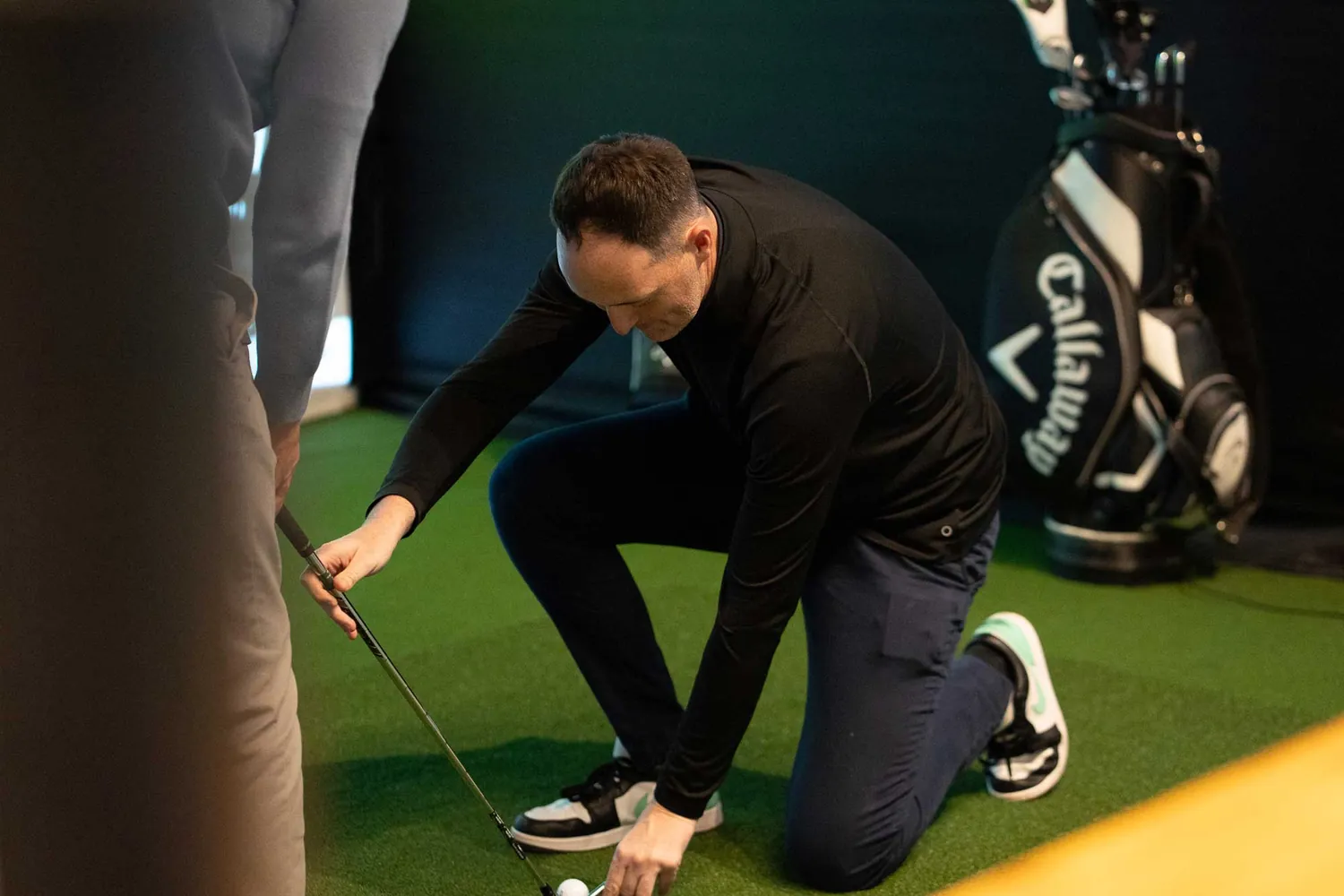 Mark Curtis coaching a golfer in a Trackman bay at Grip Golf